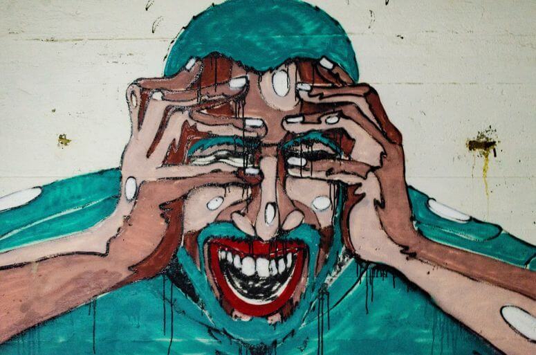 Man holding his head in frustration possibly from dealing with difficult people