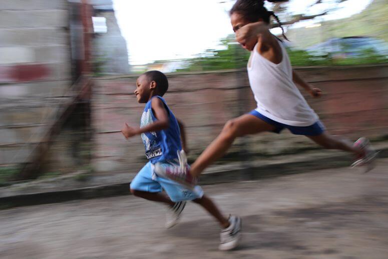 Two children practice a morning routine by running down a street