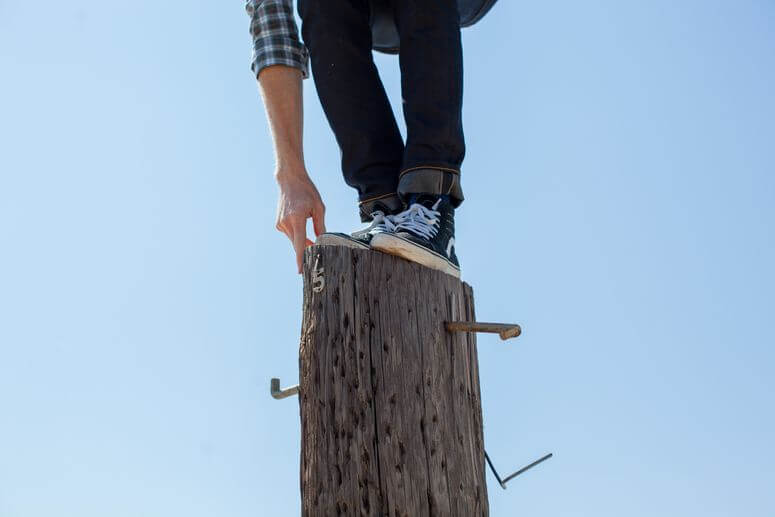 Work life balance can be like this young man trying to keep his balance on the top of a hydro pole